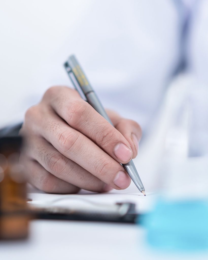 Home, Médecin ou chercheur prenant des notes dans un carnet en laboratoire